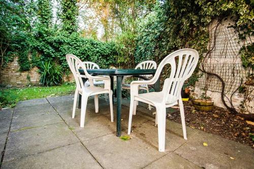 drie stoelen en een tafel met een groene tafel en stoelen bij Charming Peaceful 2 Bedroom with Parking and Garden in Londen