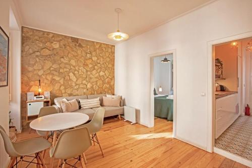 uma sala de estar com uma mesa e um sofá em Renovated cosy 1Bedroom Apartment in Santos em Lisboa