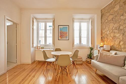 uma sala de estar com uma mesa e cadeiras e um sofá em Renovated cosy 1Bedroom Apartment in Santos em Lisboa