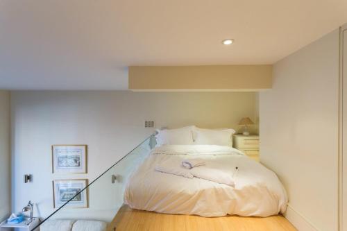 Bett in einem Zimmer mit Treppenaufgang in der Unterkunft Modern 1 bed Flat in Knightsbridge in London