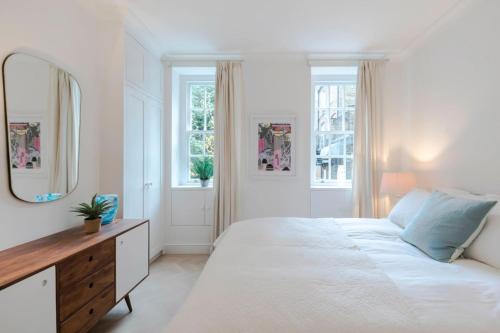 Een bed of bedden in een kamer bij Bright and Leafy 1 Bedroom Flat in the Heart of Chelsea