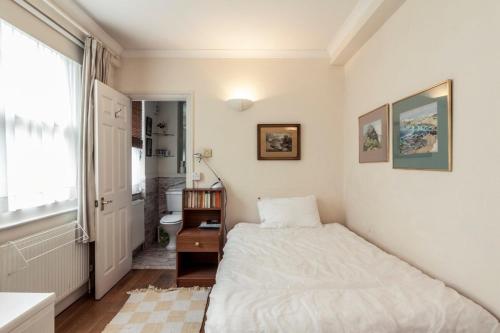 a small bedroom with a bed and a window at Bright 2 Bedroom Flat in Central London in London