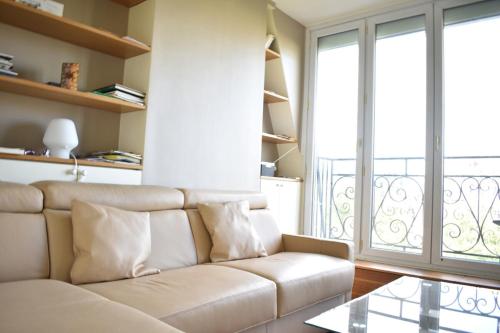 un salon avec un canapé et une grande fenêtre dans l'établissement Fully Renovated Bright Studio With High View, à Paris
