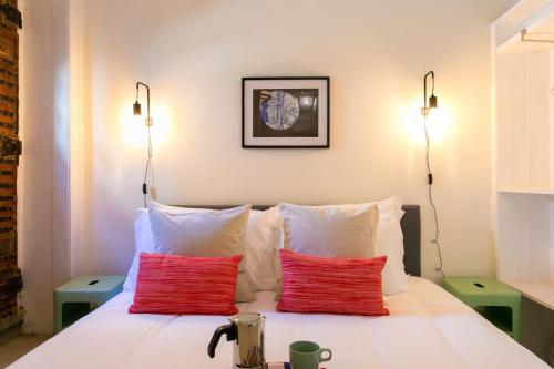 una camera con un letto con due cuscini rossi di Sunlit photographers 1Bedroom Apartment in Alcântara a Lisbona