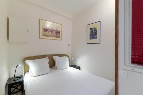 una camera con un letto bianco e una finestra di Charming 2 Bedroom Apartment in the Heart of Paris a Parigi