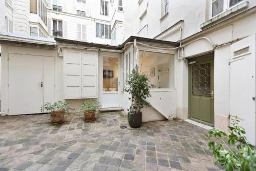 an empty courtyard with potted plants in front of a building at Modern 1 Bedroom Apartment near Eiffel Tower in Paris