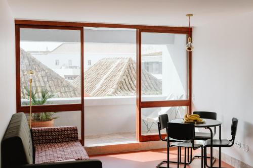 a room with a table and chairs and a large window at THE MODERNIST, Architecture experience in Faro