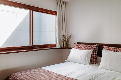 a bedroom with a bed and a window at THE MODERNIST, Architecture experience in Faro