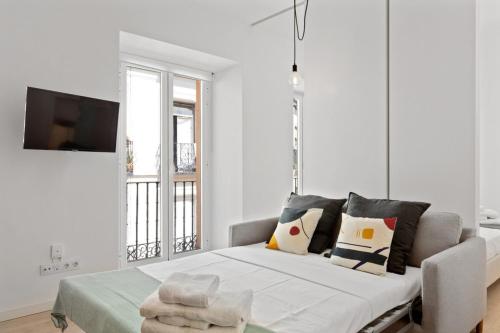 Habitación blanca con cama grande con almohadas en Modern 1 Bedroom Apartment near Lavapies, en Madrid