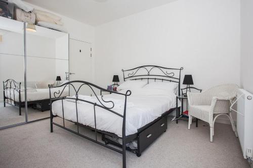 sypialnia z 2 łóżkami piętrowymi i krzesłem w obiekcie Fantastic Modern 2 Bedroom Flat in Lambeth w Londynie