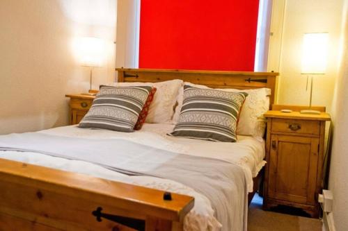 a bedroom with a wooden bed with two pillows at Thistle Street Apartment at Heart of the City Centre in Edinburgh