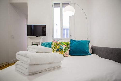 a pile of towels sitting on top of a bed at Lovely and Chic 1 Bedroom Apartment next to Atocha in Madrid
