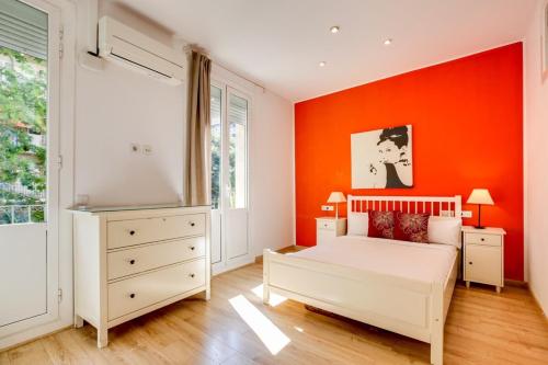 バルセロナにあるModernl 2 Bedroom in the fantastic Sant Antoni areaのオレンジ色の壁のベッドルーム1室(白いベッド1台付)