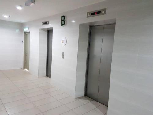 a hallway with two elevators and a b sign on a wall at Galina Somersquare Goldenhills Aprt Pasar Malam Cameron Highlands in Brinchang