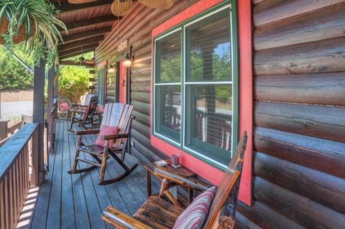 a porch of a cabin with chairs and a window at Relaxing Equestrian Retreat With Full Amenities in Tryon