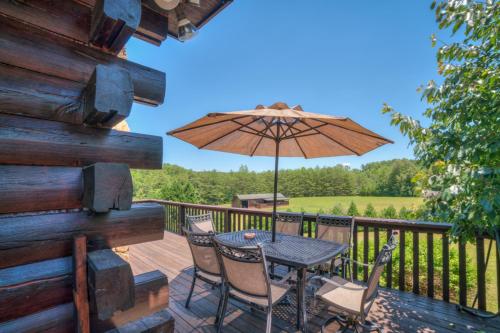 a patio with a table and chairs and an umbrella at Relaxing Equestrian Retreat With Full Amenities in Tryon