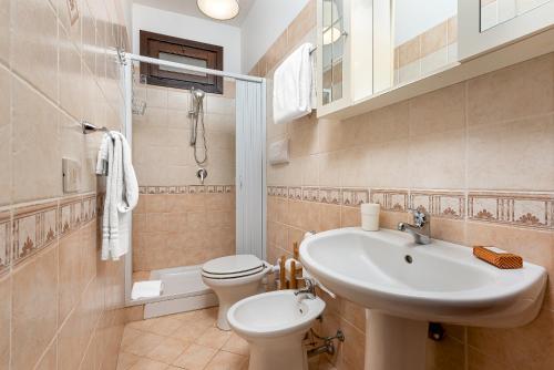uma casa de banho com um lavatório, um WC e um lavatório. em Carlottas Home em San Vito lo Capo