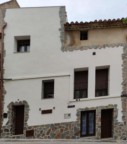 a white building with black barred windows at Casa Rural Lavernia in Cabanes