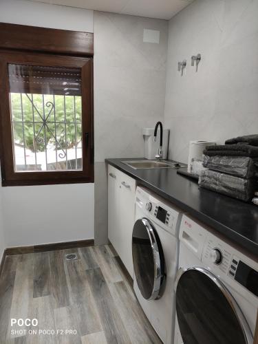 a kitchen with a washing machine and a sink at Casa Rural Lavernia in Cabanes