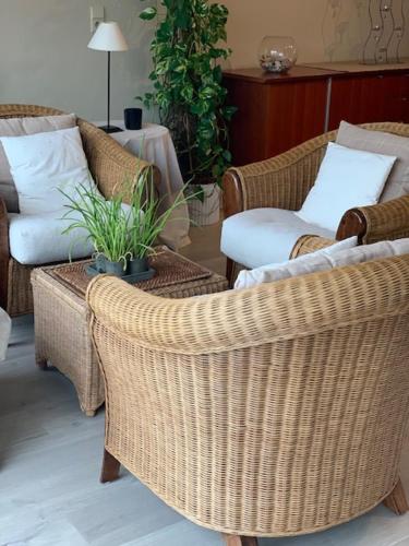 a living room with wicker chairs and a table at ORCHIS Duplex in Knokke-Heist