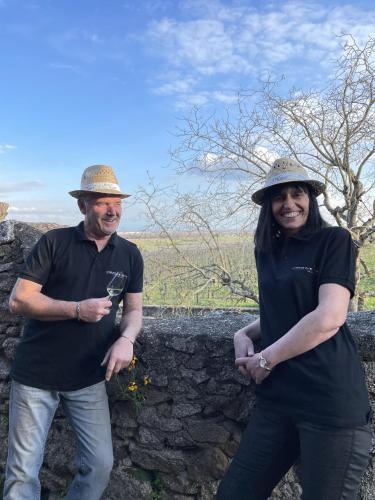 a man and a woman standing next to a stone wall at Le Refuge du Rempart in Dambach-la-Ville