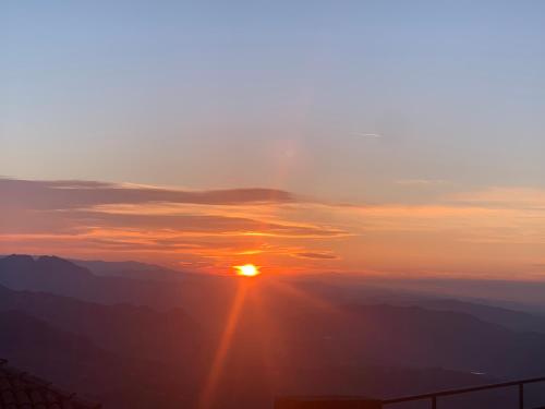 a view of the sun setting over the mountains at Borgoloto Suite 17 in San Marino