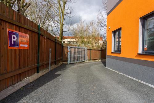 an orange building with a gate and a fence at Pension Berlin in Cheb