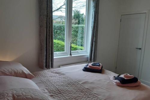 um quarto com uma cama com dois chinelos em Self contained apartment with amazing views em Jedburgh