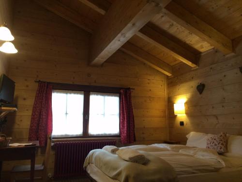 a bedroom with a bed in a wooden room at B&B La Locanda in Macugnaga