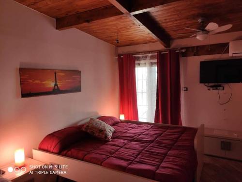 a bedroom with a bed and a window and a television at VILLA CARMEN in Castel Volturno