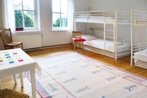 a room with two bunk beds and a table at Gästehof Brockum, altes Bauernhaus, großer Garten in Brockum
