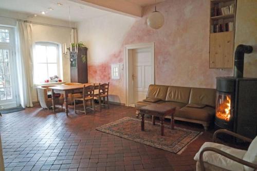 a living room with a couch and a table with a fireplace at Gästehof Brockum, altes Bauernhaus, großer Garten in Brockum