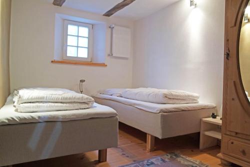 two twin beds in a room with a window at Gästehof Brockum, altes Bauernhaus, großer Garten in Brockum