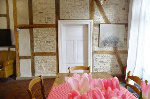 a room with a table with a pink flower on it at Gästehof Brockum, altes Bauernhaus, großer Garten in Brockum
