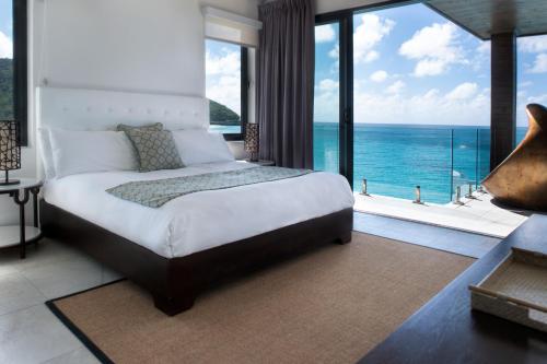 a bedroom with a bed with a view of the ocean at Tamarind Hills Resort & Villas in Johnsons Point