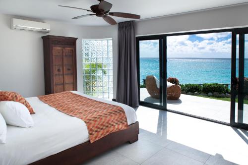 a bedroom with a bed and a view of the ocean at Tamarind Hills Resort & Villas in Johnsons Point