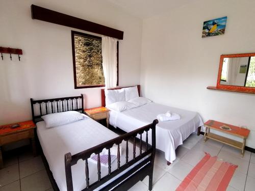 מיטה או מיטות בחדר ב-Pousada Recanto dos Pássaros