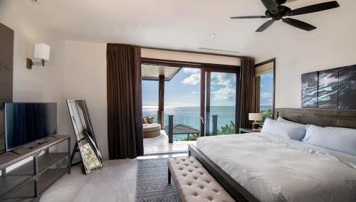a bedroom with a bed and a view of the ocean at Tamarind Hills Resort & Villas in Johnsons Point