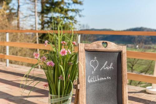 a chalkboard sign next to a vase of flowers at Ferienparadies Bodensee Fewo2 in Billafingen