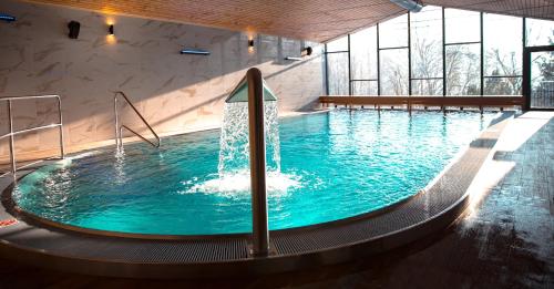 a swimming pool with a large swimming pool tub at Wellness Hotel Astra in Špindlerův Mlýn