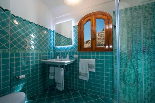 a blue tiled bathroom with a sink and a shower at Casa Leucosia, Positano centro in Positano