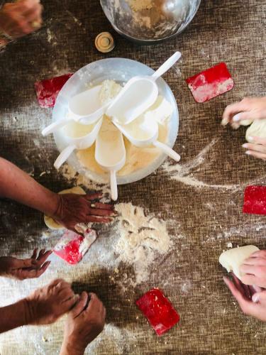 a group of hands standing around a bowl of food at LaChiusa Tuscany in Montefollonico