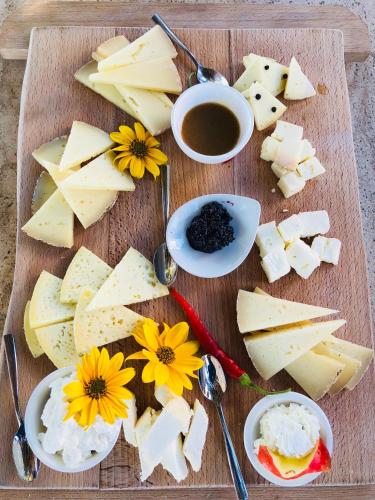 a wooden cutting board with cheese and flowers on it at LaChiusa Tuscany in Montefollonico