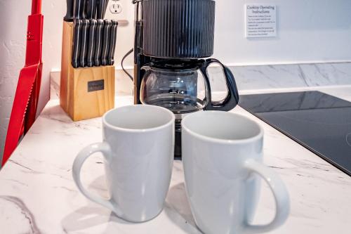 two white mugs sitting on a counter with a blender at Kanab Suites in Kanab