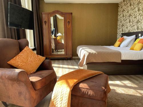 a room with two beds and a chair and a mirror at Hotel restaurant Stad Munster in Winterswijk