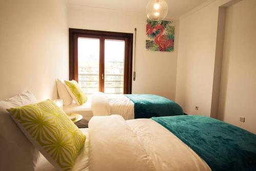 a living room with two beds and a window at Casa da Torre com garagem gratuito in Aveiro