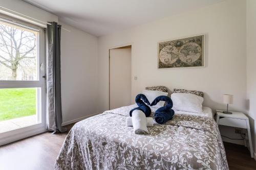 - une chambre avec un lit avec un animal rembourré dans l'établissement LE FOUGERES, à Rennes