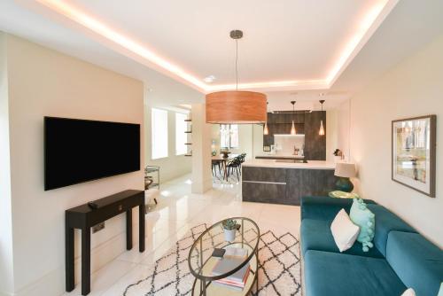 a living room with a blue couch and a tv at The Old Fire Station Luxury Apartment in York