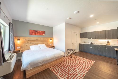 a bedroom with a large white bed and a kitchen at Kanab Suites in Kanab