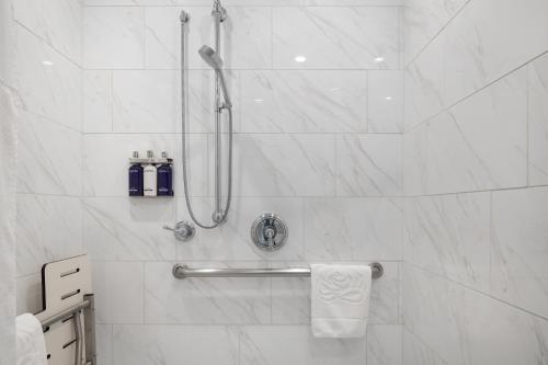 a bathroom with a shower with white marble walls at The Millwood in Millbrae